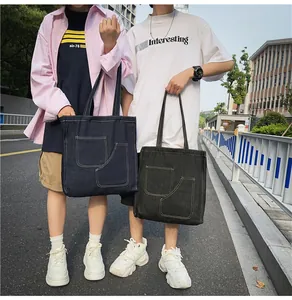 Detail of denim tote bags featuring contrast stitching and practical front pockets