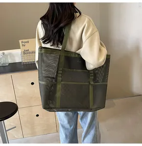 Bolso tote de malla verde oliva visto desde atrás con gran capacidad y bolsillos externos
