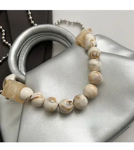 Detailed close-up of marble textured beads and yellow accents on a silver metal chain