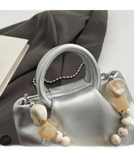Detail of silver cloud handbag featuring marble bead decoration and metallic leather texture