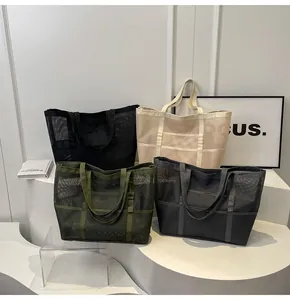 Bolsos tote de malla en negro beige oliva y gris en un soporte de exhibición