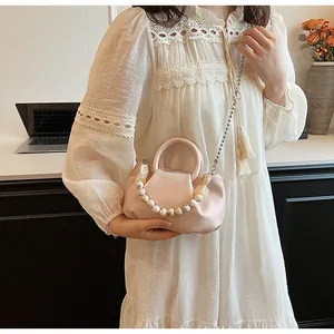 Detail of pink dumpling bag with pearl handle and silver chain strap for women