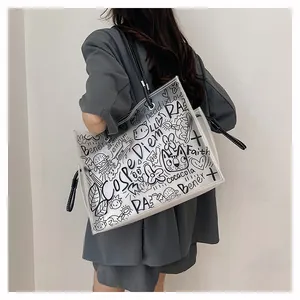 Close-up of graffiti transparent jelly tote bag with black leather straps on model