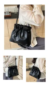 Close-up of black ruched bucket bag with delicate gold accents and sleek drawstring