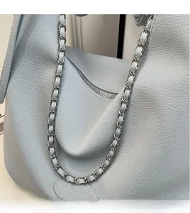 Detail of light blue lychee pattern leather tote with silver metal chain strap