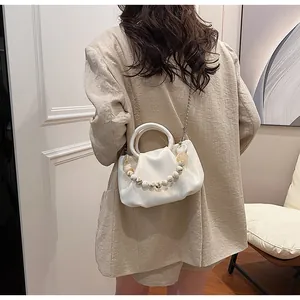 White cloud crossbody bag with marble bead strap and metallic chain detail worn by model