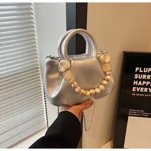 Close-up of silver cloud bag featuring marble resin beads and metallic chain strap