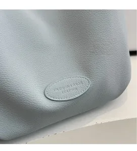 Close-up of light blue lychee pattern leather with a fashion-stamped oval label