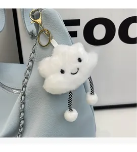 Detail of white fluffy cloud charm with smile embroidery on blue chain bag