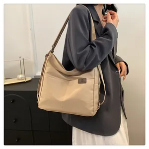 Detail der beigen Schultertasche mit Außentaschen und minimalistischem Design