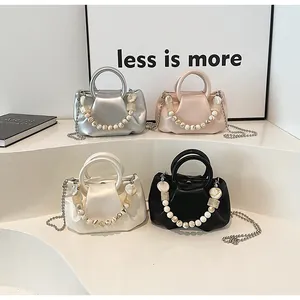 Detail of mini pleated dumpling bags with marble bead handles and metal chains in four colors