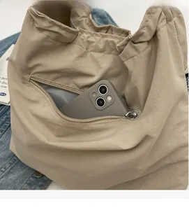 Makroaufnahme einer beige Nylon-Tragetasche mit praktischer Reißverschlusstasche für Handys