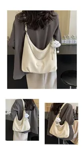 Detail of lychee pattern hobo bag with silver chain and white cloud plush charm