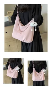 Detail of light pink hobo bag with silver chain strap and fluffy white cloud pendant