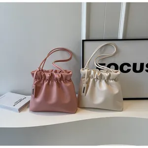 Detail view of pink and white ruched drawstring bucket bags made of premium PU leather