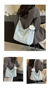 Light blue hobo shoulder bag with silver chain and cute plush cloud charm on suit