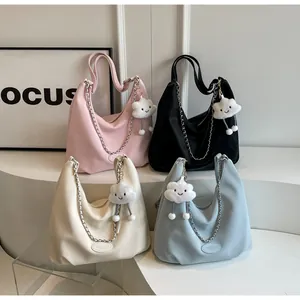 Detail of four colorful hobo bags featuring chain straps and cloud plush charms