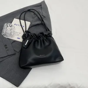 Minimalist black pleated bucket bag in premium faux leather with dual slim shoulder straps