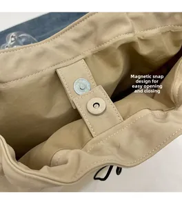 Close-up of magnetic snap closure on beige canvas bucket bag with neat stitching details