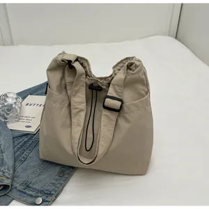 Detail der beige Nylon-Einkaufstasche mit schwarzem Kordelzug und Seitentaschen