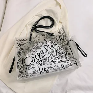 Transparent PVC graffiti tote bag with black street art sketches and slim shoulder straps