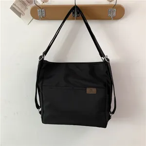 Minimalistische schwarze Damen-Tragetasche aus Nylon mit Vordertaschen und Schulterriemen