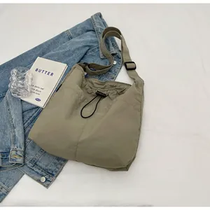 Detail der hellolivgrünen Umhängetasche aus Nylon mit Kordelzug und verstellbarem Gurt