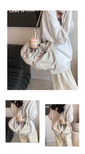 Detail of cream drawstring bucket bag with a plush latte cup charm and pleated texture