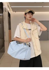 Práctica bolsa de viaje azul claro con logo ANASTTCA mostrada en un modelo al hombro