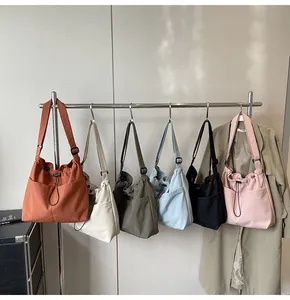 Row of colorful drawstring canvas bucket bags with large front pockets and adjustable straps