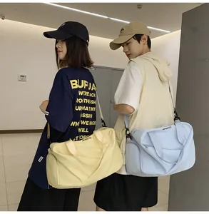 Dúo de modelos con bolsas de viaje amarillas y azul claro en un pasillo interior moderno