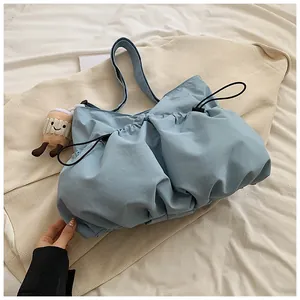Close-up of light blue puffy drawstring bucket bag with a cute coffee cup plush charm