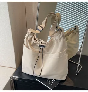 Detail of off-white canvas bucket bag with drawstring closure and front double pockets