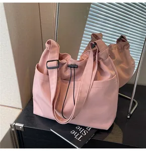Detail view of pink nylon bucket bag with drawstring closure and adjustable strap