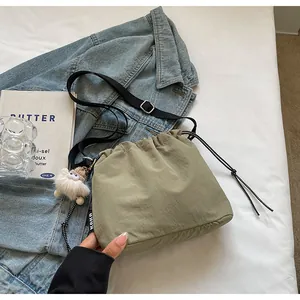 Détail du sac seau vert à cordon avec étiquette KOKO et bandoulière noire réglable