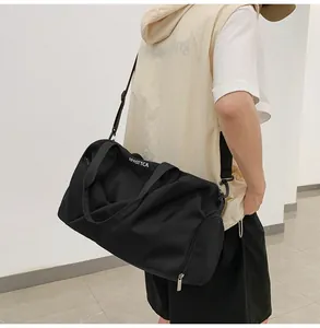 Vista lateral de una persona con un bolso deportivo negro con logo blanco y correa de hombro