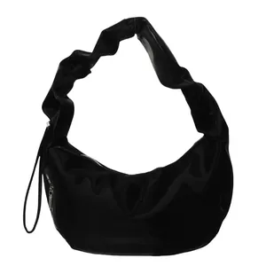 Minimalist black pleated crescent shoulder bag with glossy finish and ruched strap