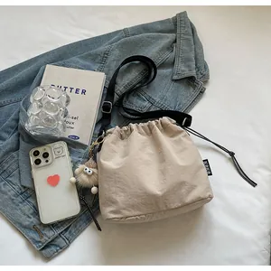 Gros plan du sac seau beige avec étiquette KOKO et cordon de serrage à pois