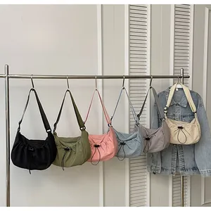 Détail de plusieurs sacs en nylon plissé de différentes couleurs sur des cintres