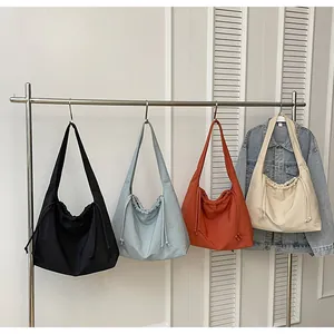 Dettaglio di grandi borse tote in tela con coulisse in quattro colori neutri