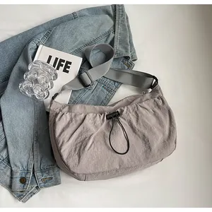 Détail d'un sac bandoulière plissé gris avec sangle ajustable et nylon texturé