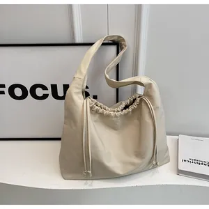 Dettaglio delle pieghe della coulisse e della trama della pelle crema opaca di questa borsa