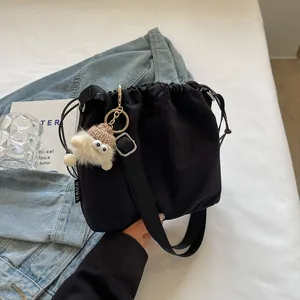 Grand sac seau noir à cordon avec breloque en peluche et bandoulière réglable