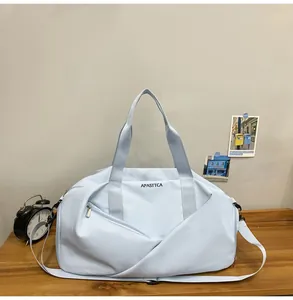 Primer plano de bolsa de deporte azul claro con logo APASTTCA sobre una mesa de madera