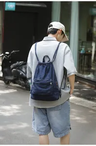 Sac à dos décontracté en denim bleu marine avec cordon de serrage et poche zippée devant