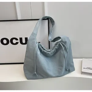Dettaglio della borsa a tracolla azzurra con morbido tessuto a pieghe e coulisse