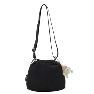 Sac seau en nylon noir avec cordon de serrage, sangle réglable et breloque peluche