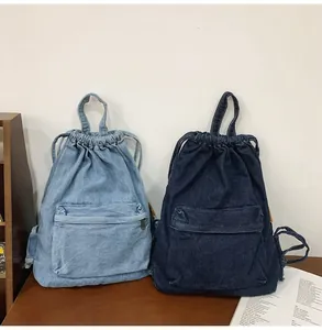Détail de sacs à dos en denim bleu clair et foncé avec cordon et poches zippées