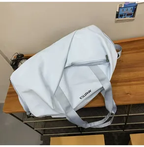 Detalle del bolso de viaje azul con asas resistentes y logotipo APASTTCA impreso