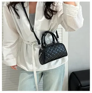 Detail of black quilted bowling bag featuring silver hardware and a minimalist leather texture